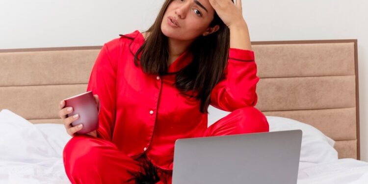 schöne-frau-rote-pyjamas-sitzt-im-bett-burnout-marokko