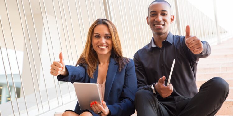 collègues-heureux-tenant-tablettes-montrant-pouces-en-l'air-escaliers-maroc-objectifs-commerciaux