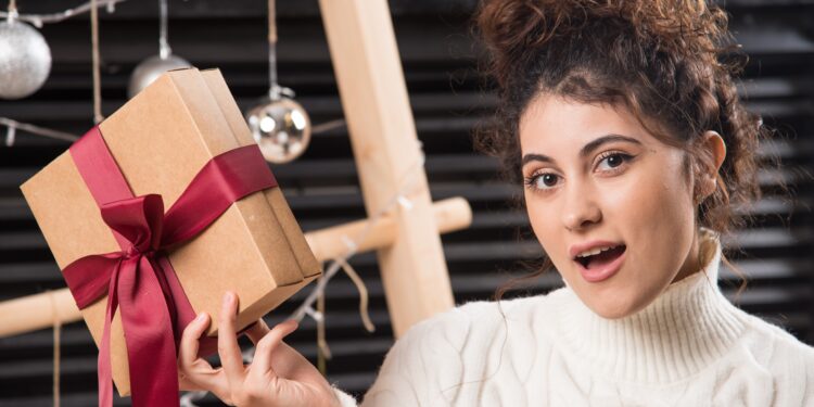Une jeune femme tenant une boîte cadeau avec un nœud
