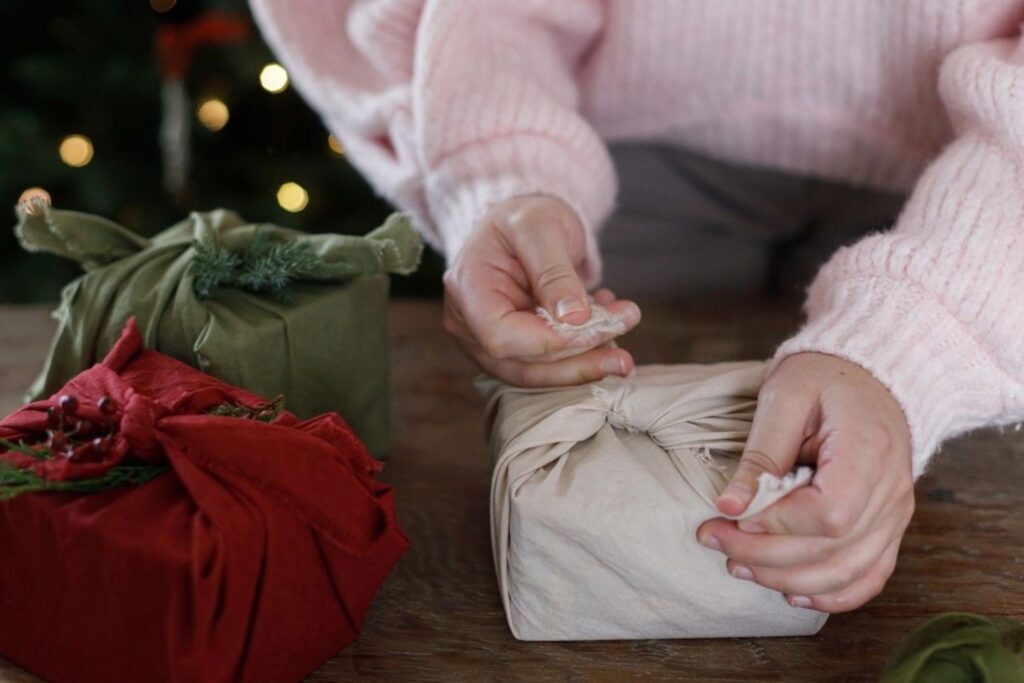 هدية أنيقة ملفوفة بقماش مغربي صديق للبيئة، مربوطة بعقدة تقليدية، تجسد تغليف الهدايا المستدام الخالي من النفايات، وتحتفي بالتراث الحرفي مع تقليل الأثر البيئي