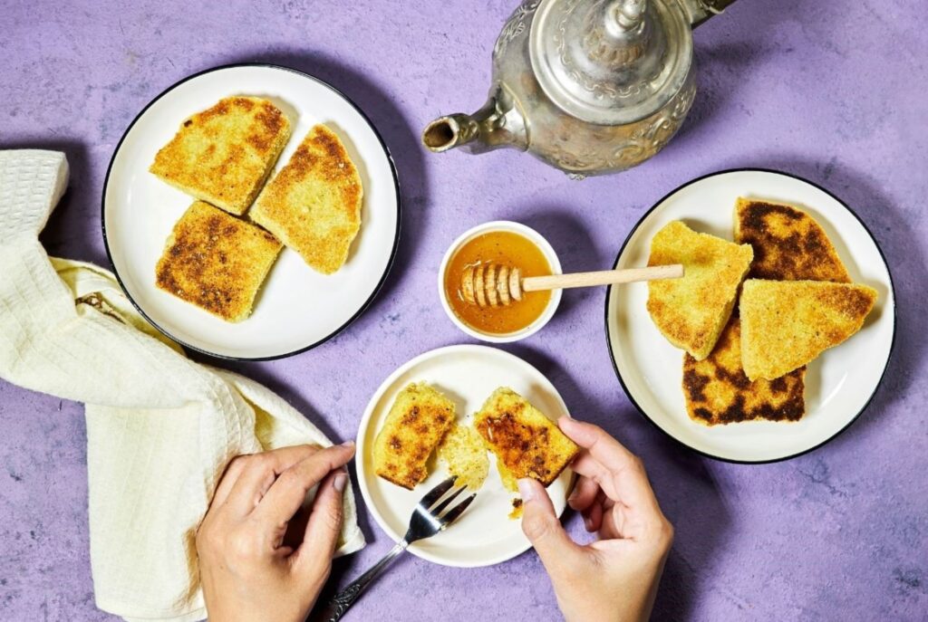 Harcha marroquí sin gluten hecha con harina de maíz, servida con mantequilla de miel para un desayuno auténtico y saludable, mostrando recetas tradicionales adaptadas para comidas matutinas seguras para celíacos