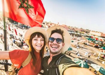 Touristen erkunden die farbenfrohen Souks der Medina von Marrakesch während eines Winterurlaubs im Dezember und durchsuchen traditionelle Gewürze, Textilien und handwerkliche Waren bei angenehm milder Witterung