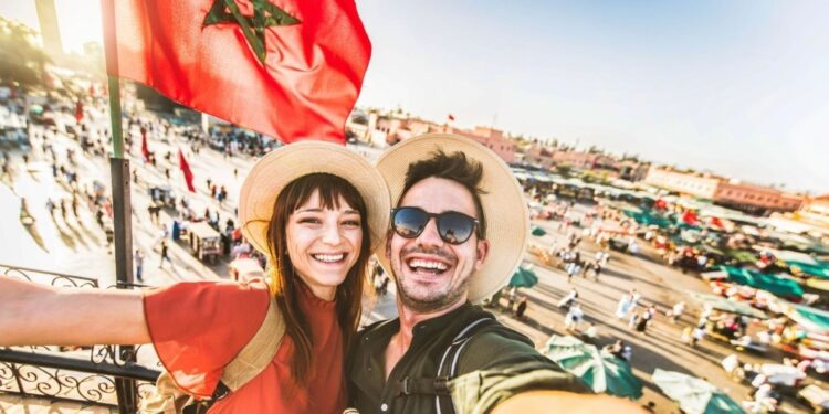 Tourists exploring colorful Marrakech medina souks during December winter getaway, browsing traditional spices, textiles, and handcrafted goods in comfortable mild weather