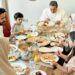 Familia marroquí reunida alrededor de una tradicional fiesta de Eid con cuscús y tajine durante las celebraciones de la temporada navideña, representando tradiciones familiares multiculturales que mezclan costumbres islámicas con la hospitalidad marroquí