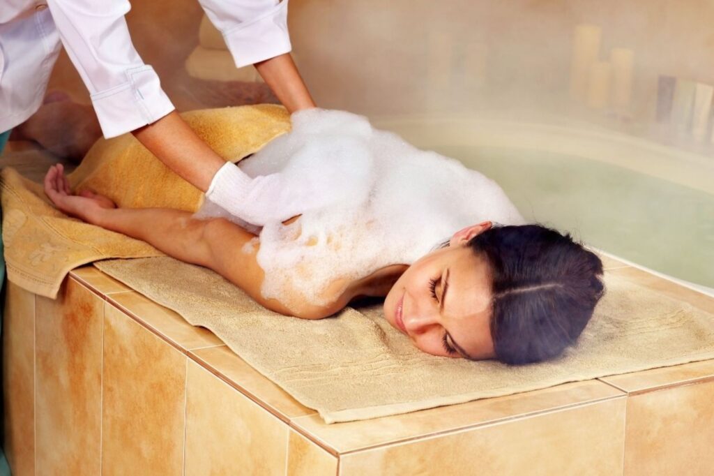 Traditionelles marokkanisches Hammam-Dampfbadritual zur Festlegung achtsamer Absichten durch Reinigungszeremonie mit schwarzer Seife, Rhassoul-Ton und Arganöl, das einen Wellness-Ansatz für die Transformation im Jahr 2026 darstellt