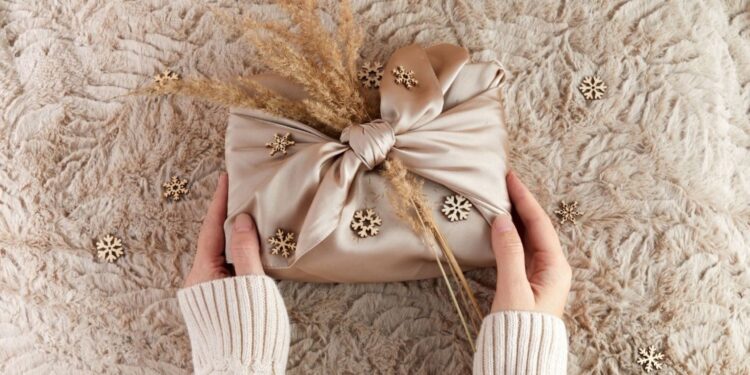 تغليف هدايا صديق للبيئة جميل باستخدام النسيج التقليدي المغربي حندرة بنقوش هندسية وترتر، يوضح تقنية فوروشيكي المستدامة التي تحل محل الورق الهدر بالمنسوجات الحرفية القابلة لإعادة الاستخدام