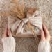 Marokkaanse handira textielstof cadeauverpakking Furoshiki traditioneel - MAwebzine Prachtige milieuvriendelijke cadeauverpakking met traditioneel Marokkaans handira textiel met geometrische patronen en pailletten, demonstrerend de duurzame Furoshiki techniek die verspillend papier vervangt door herbruikbare ambachtelijke stoffen