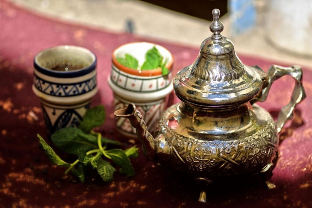 Mesa de desayuno tradicional marroquí sin gluten con té de menta fresco, zumo de naranja exprimido y ensaladas coloridas, que representa una comida matutina saludable, naturalmente sin trigo, en honor a la cultura marroquí