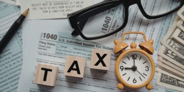 Moroccan small business owner consulting with accountant on year-end tax planning with financial documents and receipts, representing strategic deduction maximization and DGI compliance preparation