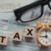 Moroccan small business owner consulting with accountant on year-end tax planning with financial documents and receipts, representing strategic deduction maximization and DGI compliance preparation
