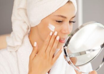 Frau trägt feuchtigkeitsspendende Gesichtscreme als Teil der Winterhautpflege-Routine, die Marokkos Trockenklima-Herausforderungen bewältigt und zeigt, wie man richtig die Hautbarriere schützt und Hyaluronsäure in Wüstenbedingungen anwendet