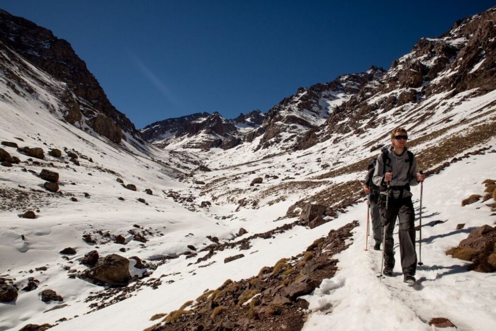 Winter trekking Atlas Mountains with hiker using proper safety gear and equipment