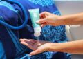 zonnebrand-aanbrengen-unsplash - MAwebzine Een Marokkaanse vrouw die zonnebeschermingscrème op haar gezicht aanbrengt op een zonnige straatje in de medina