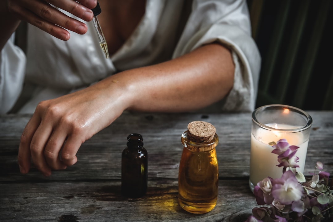 A woman applying argan oil as part of her sun protection and recovery skin care routine