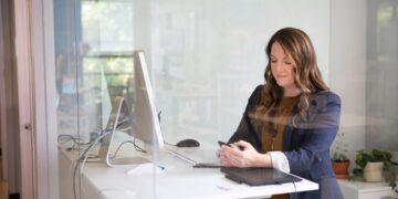 business-women-unsplash - MAwebzine Een zakenvrouw loopt langs de kust van Essaouira tijdens het juni Marokko-reizoen, met Atlantische winden op de achtergrond.