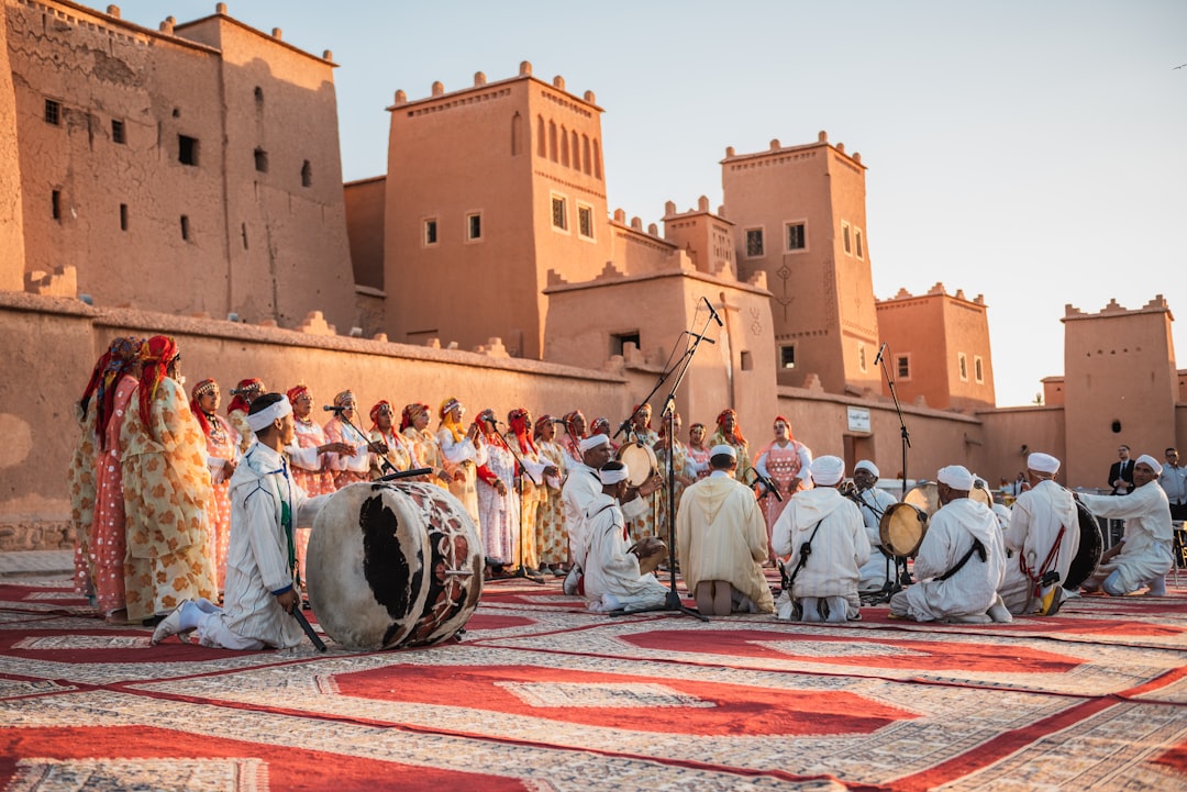 Performers en bezoekers vullen een Marokkaanse medina-plein tijdens een juni Marokko-muziekfestivalviering.