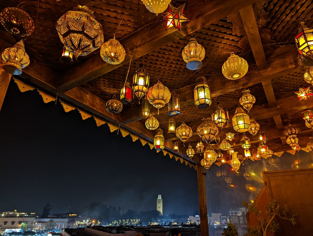 Ein Reisender sitzt auf einer Dachterrasse eines privaten Riads in Marokko und beobachtet das Atlas-Gebirge in der Dämmerung