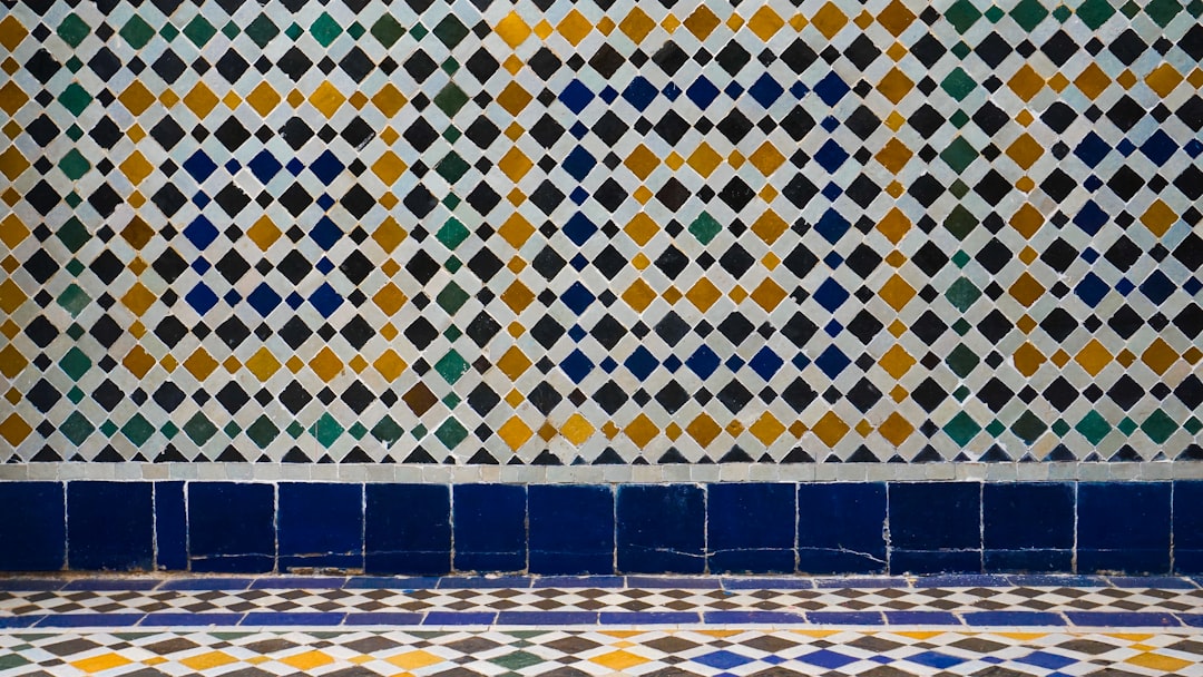 Een interieurontwerper die een moderne keuken presenteert met een donkerblauwe zellige tegelachterwand