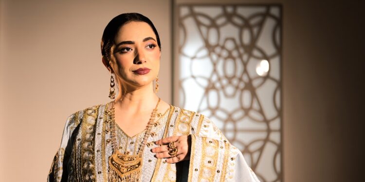 moroccan-woman-wearing-handwoven-caftan-unsplash - MAwebzine Una mujer marroquí con un caftan de verano tejido a mano que representa la belleza de la moda marroquí lenta a la luz natural.