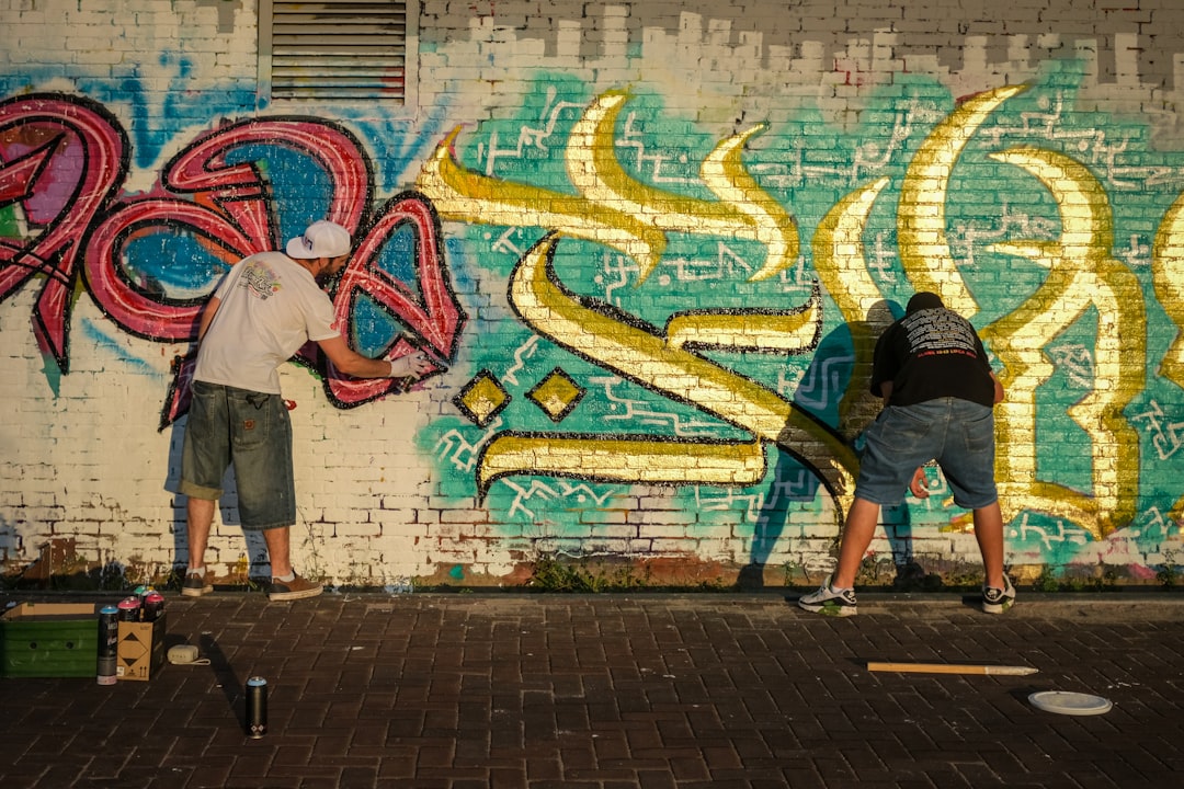 Een Marokkaanse kalligrafieontwerper brengt gedurfde Arabische lettervormen aan op een groot canvas in een helder atelier