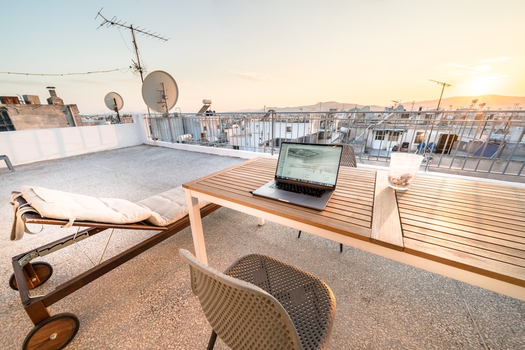 Een externe werker op een dak in Essaouira met zicht op de Atlantische kust, wat de groeiende scene van nomaden en startups van Marokko vertegenwoordigt