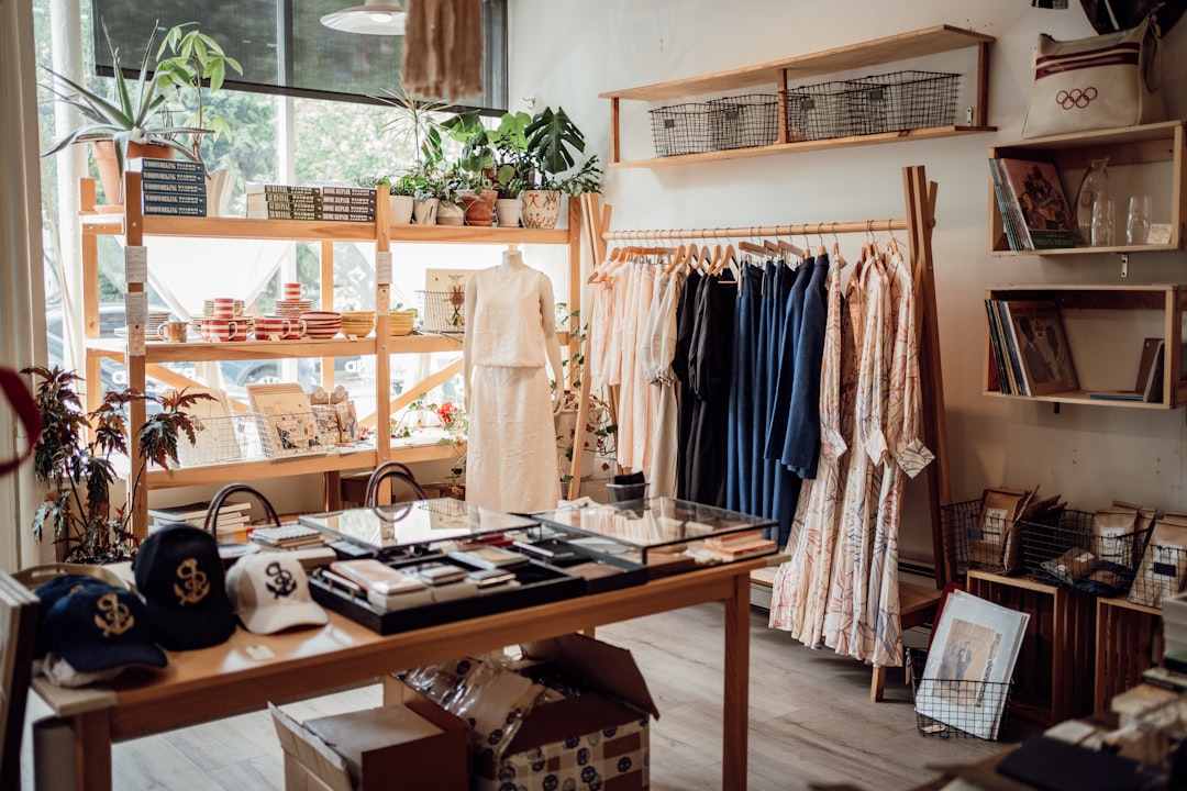 Una mujer explorando una boutique de moda marroquí hecha éticamente, rodeada de prendas de verano de telas naturales.