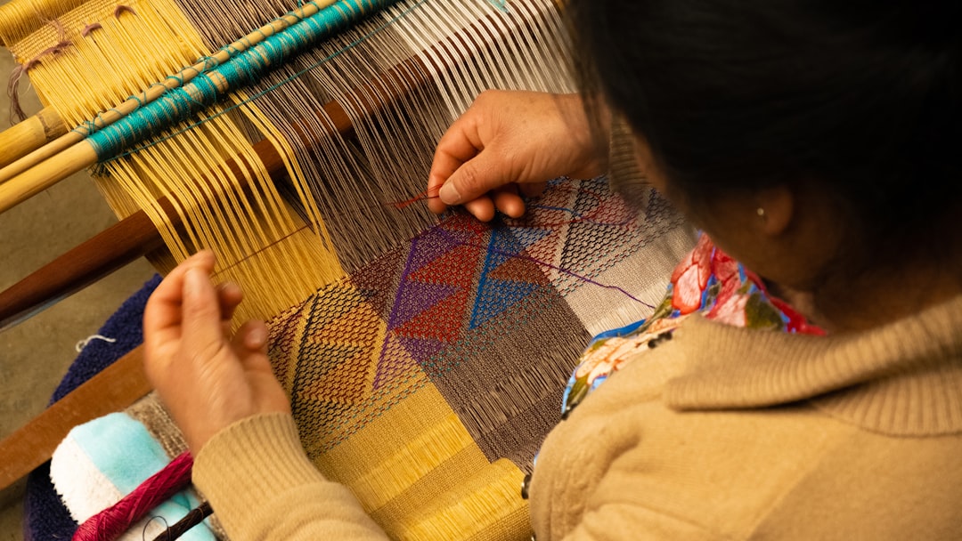 Una artesana marroquí experta tejiendo tela a mano en un taller de medina, una práctica central de la moda marroquí sostenible.
