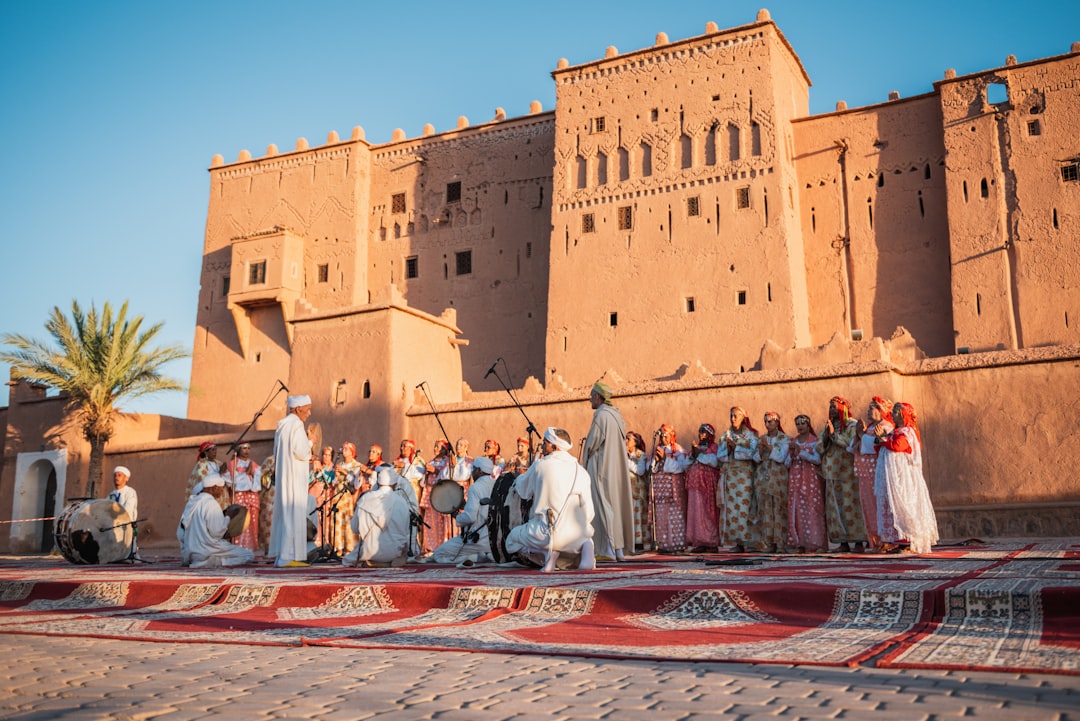 Bezoekers kijken naar een traditionele dansvoorstelling op het populair kunstfestival in het historische El Badi Palace van Marrakech