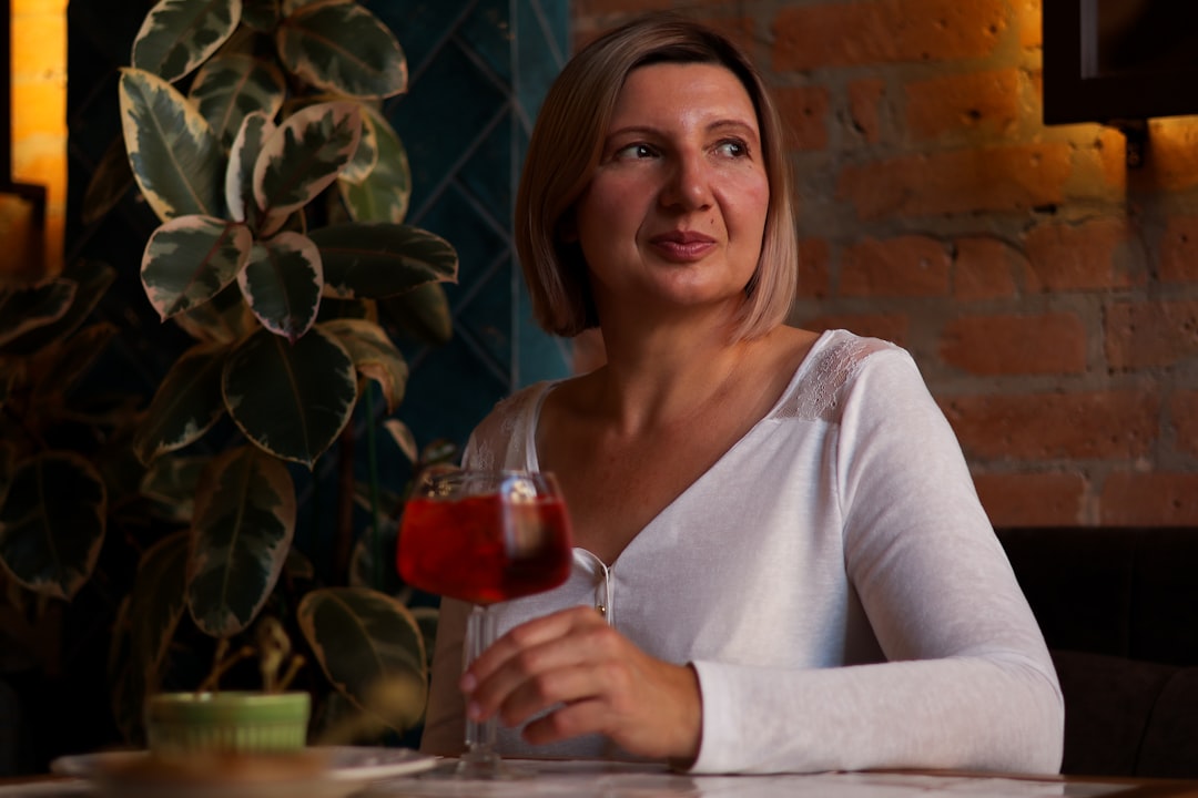 Een glimlachende vrouw met een helder rood glas hibiscus jus de bissap, een van de populairste koude Marokkaanse dranken in de zomer