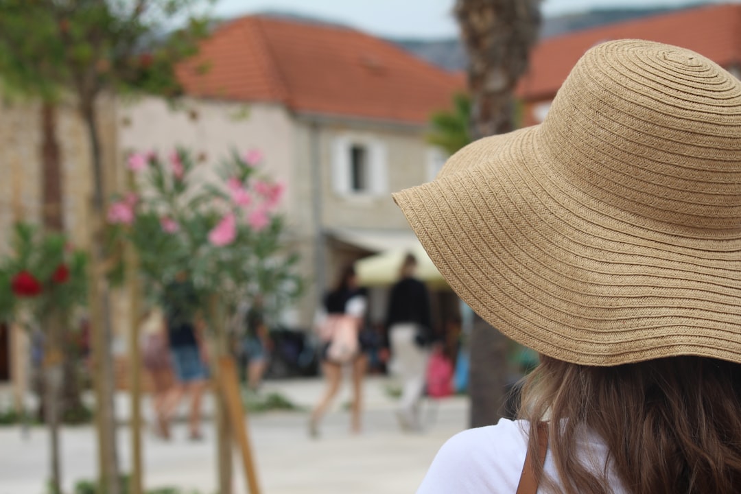 A woman wearing a wide-brimmed hat for sun protection while walking through a Moroccan market