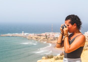 Een vrouw loopt langs het Agadir-strand bij zonsopgang en geniet van een junimorgen aan de Atlantische kust van Marokko tijdens een Agadir-weekend
