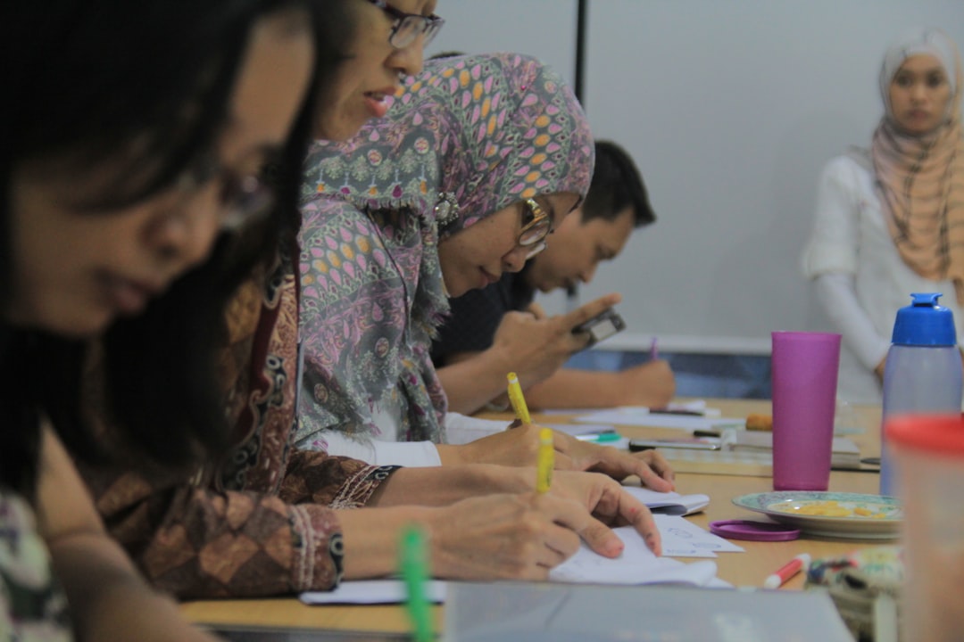 Een student oefent Marokkaanse kalligrafie met inkt en een traditionele pen tijdens een workshop in Fez