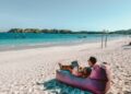 Een digitale nomade die aan een laptop werkt in een coworking space aan de Atlantische kust van Marokko met oceaanzicht op de achtergrond