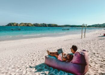 Een digitale nomade die aan een laptop werkt in een coworking space aan de Atlantische kust van Marokko met oceaanzicht op de achtergrond