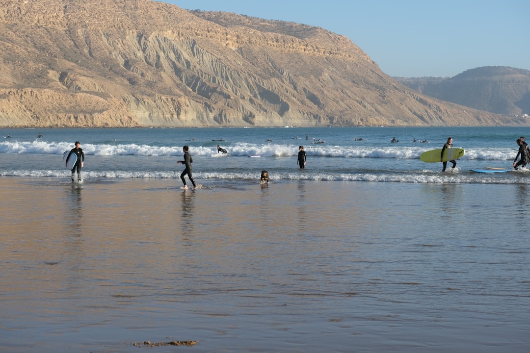 A student at a surf school in Morocco rides a gentle Atlantic wave during a structured summer coaching session