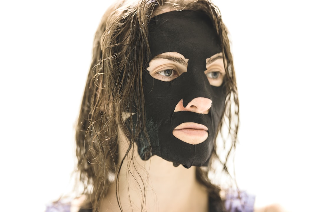 Een vrouw die een rhassoulkleimasker op haar hoofdhuid aanbrengt, een essentiële stap in een zomerse arguanolie-haarverzorgingsroutine