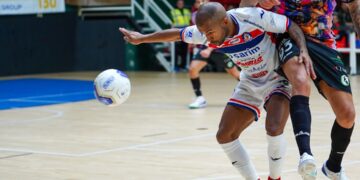 A Moroccan handball player celebrates during an African handball championship match in front of a passionate crowd
