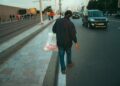 A traveller carrying a reusable tote bag to reduce plastic use while shopping in a Moroccan souk
