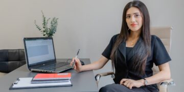 moroccan-businesswoman-signing-contract-office-unsplash - MAwebzine A professional reviewing an employment contract while hiring local talent in Morocco at a modern Casablanca office