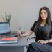 moroccan-businesswoman-signing-contract-office-unsplash - MAwebzine A professional reviewing an employment contract while hiring local talent in Morocco at a modern Casablanca office