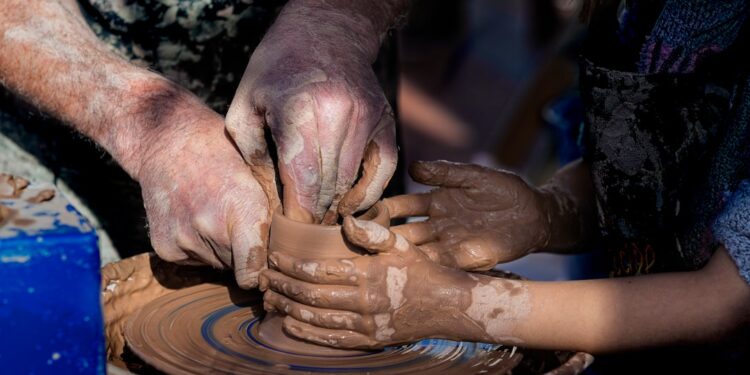 pottery-workshop-unsplash - MAwebzine Een moeder en kind vormen klei samen tijdens een ambachtelijke workshop in een traditioneel aardewerkstudio in Fez tijdens een vakantie in Marokko