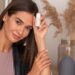 woman-applying-hair-oil-unsplash - MAwebzine امرأة مغربية تضع زيت الأرغان على شعرها كجزء من روتين العناية بالشعر الصيفي