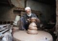 A Fassi artisan demonstrates Moroccan pottery hand-throwing technique on a foot-powered wheel in Ain Nokbi