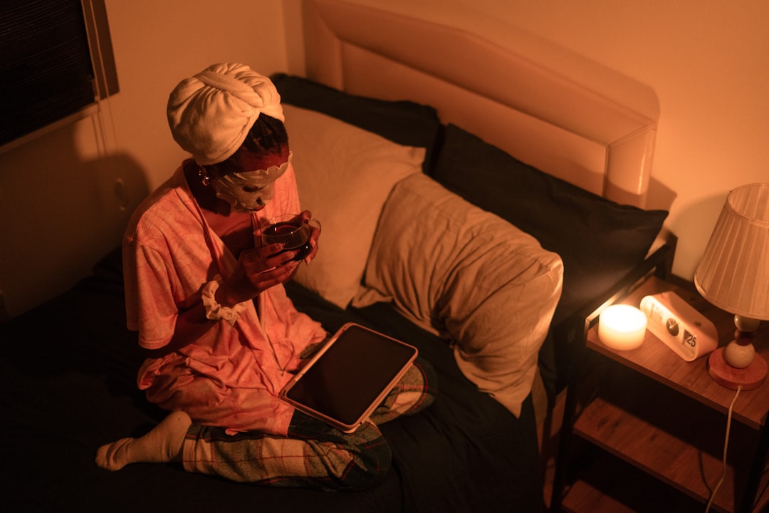 A Moroccan woman following her evening ritual with dim candlelight and orange blossom water before sleep on a warm night.