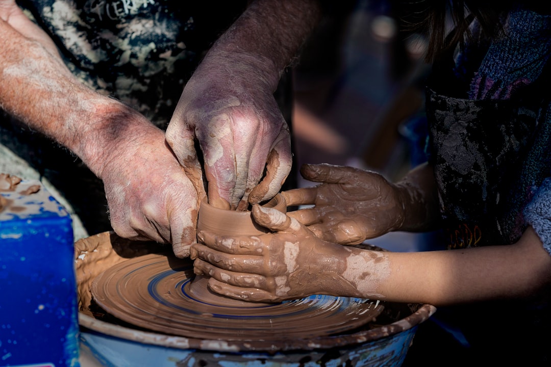 A visitor tries Moroccan pottery hand-throwing under the guidance of a master artisan in Ain Nokbi