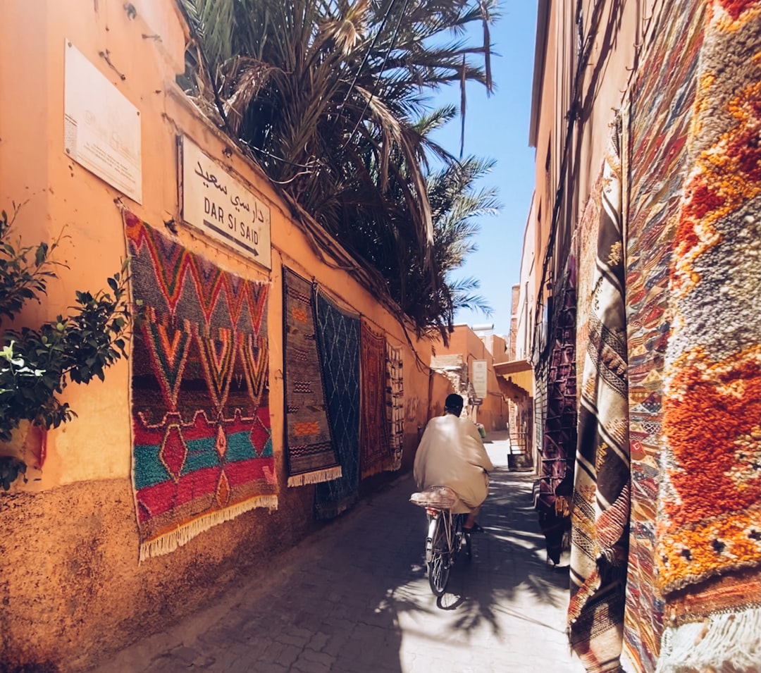A visitor studying colorful murals on the walls of Asilah during the Asilah Moussem festival