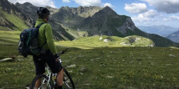 cyclist-cycling-in-mountain-unsplash - MAwebzine A road cyclist ascending a steep Moroccan cycling route through the High Atlas Mountains at sunrise