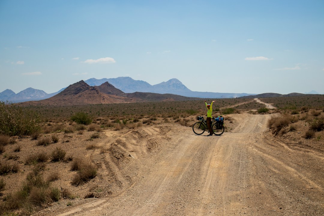 A gravel rider navigating a rocky canyon on a challenging Moroccan cycling route in the Dades Gorge area