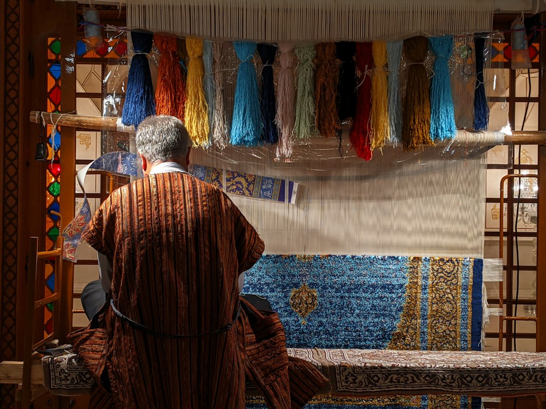 A Moroccan artisan craftsman finishing a wool garment by hand, that forms of a lasting capsule wardrobe