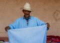 A Moroccan artisan weaving fabric inside a cooperative, showing the process behind building a capsule wardrobe
